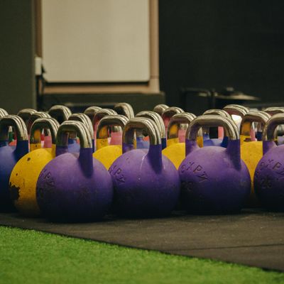 Close-up of a kettlebell on a textured wooden floor.