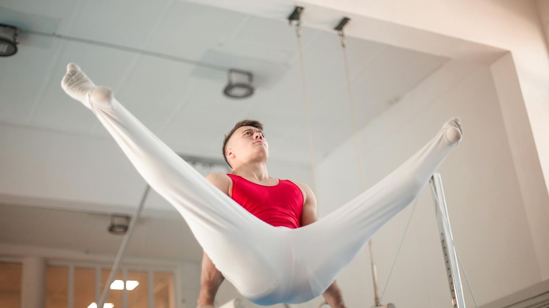 Man performing a controlled strength exercise in a minimalist gym setting.